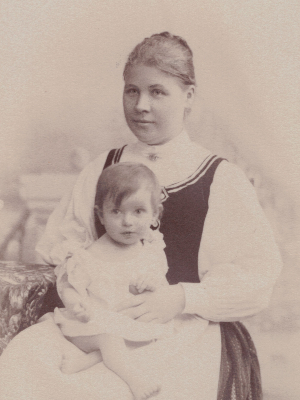 [Translate to Niederländisch:] Historische Schwarz-Weiß-Fotografie. Olly als Baby auf dem Schoß ihrer Mutter.