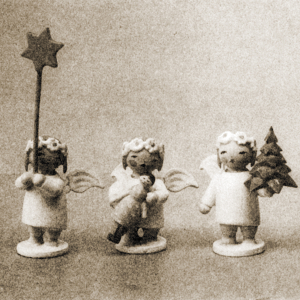 [Translate to Niederländisch:] Drei Margeritenengel. Sie halten jeweils einen Stern, ein Bäumchen und eine Puppe. Schwarz-Weiß-Aufnahme.