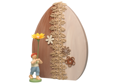 Blumenkind vor einem Osterei aus Holz